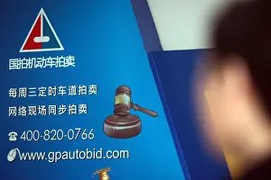 A billboard of Shanghai Guopai Motor Vehicle Auction Co. Ltd is seen in the hall of the pay center for license plates in Shanghai, China, 19 March 20