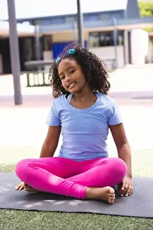 Demonstrating Prints: Biracial girl practices yoga outdoors at school