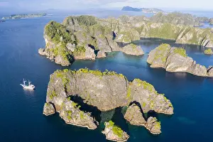 A bird's eye view shows healthy reefs surrounding remote limestone islands in Raja Ampat. This area is known for its incredible marine biodiversity