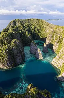 A bird's eye view shows healthy reefs surrounding remote limestone islands in Raja Ampat. This area is known for its incredible marine biodiversity