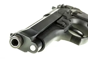 Semi Prints: detail of a black 9mm pistol barrel isolated over a white background