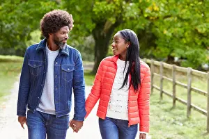 Leisure Activities Prints: Black adult couple, boyfriend, girlfriend walk holding hands in the countryside, close up