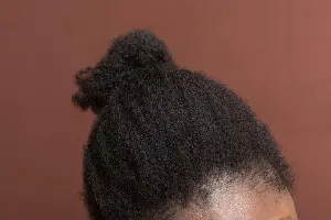 Back View Prints: Black afro curly hair with shrinkage, Type 4c hair that is dry with a brown background