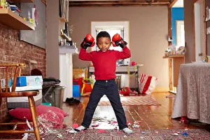Boxer Prints: Black boy posing with boxing gloves in messy living room