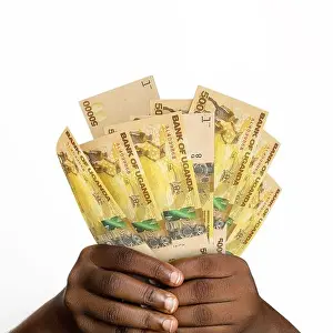 Black Hand Prints: Black hands holding 3D rendered 50000 Ugandan shilling notes