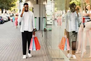 Shopper Prints: Black man talking on mobile phone holding shopping bag