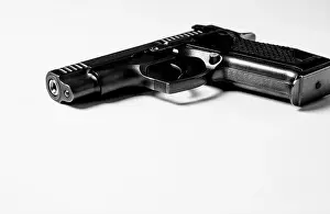 Isolate Prints: Black metal pistol lies on a white background, close-up