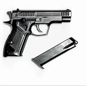 Cartridge Prints: A black pistol with a magazine for cartridges lies on a white background