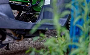 Stare Prints: A black and white cat staring intently from behind a parked motorbike and some grass