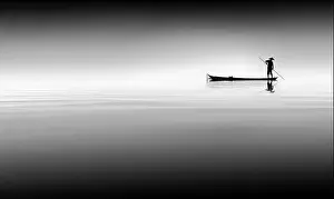 Stillness Prints: Black and white fine art photo of Vietnamese man fishing from boat on river Bon