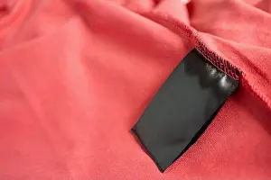 Folded Prints: blank black color clothing label on red t shirt