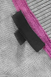 Underside Prints: Blank black fabric label on grey knit background closeup