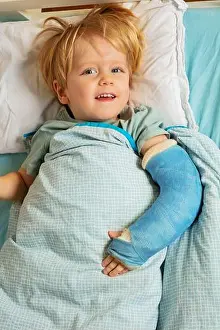 Careless Prints: Blond boy in hospital bed with plaster cast on the broken hand