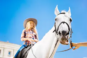 Teenage Girl Prints: Blonde-haired teenage girl enjoying her horse riding lesson