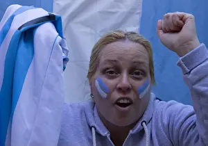 Young Girl Prints: Blonde woman with a flag and face painted in the colors of Argentina watching a football match