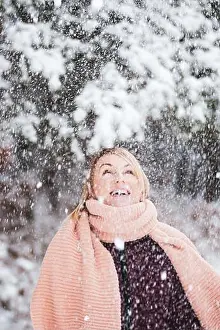 Snowfall Prints: Blonde woman with purple coat and pink scarf enjoys of heavy snowing