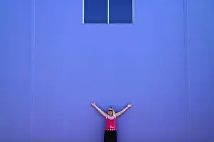 Excellent Prints: Blonde woman wearing sunglasses raising hands and leaning against a purple wall