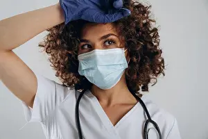 Bask Prints: In the blue gloves and mask. Beautiful doctor woman is in the studio