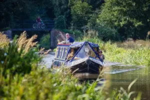 Side Prints: A blue narrowboat Lena Mary leisurely cruises on the Wey Navigation through unspoilt countryside near Send