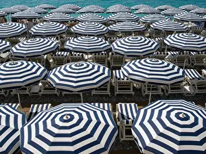 Parasols Prints: Blue and white beach umbrellas by the sea on the French Riviera