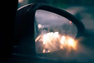 Travelers Prints: Blurry car lights reflected in the rear view mirror