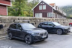 Electric Vehicle Prints: BMW electric car being recharged at a power charging station in a hotel car park in Flam village