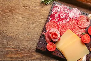 Deli Prints: Board with assortment of tasty deli meats and cheese on wooden background