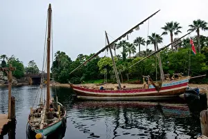Disney Prints: Two boats on the river with sails furled and the dock on the left