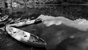 Kayaking Prints: Boats on the shore of a lake with the reflection of sky and hills falling on water