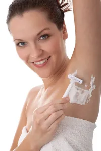 Body Care Prints: Body care - Smiling woman shaving her armpit using white razor