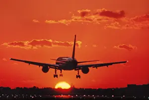 Cumulus Prints: Boeing 757 jet in the air runway lights heading into an golden orange sky at sunset sunrise dusk showing jet thrust