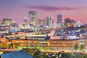Boston, Massachusetts, USA skyline with bridges and highways at dusk