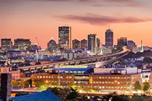 Boston, Massachusetts, USA skyline with bridges and highways at dusk