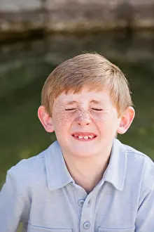 Screwing Prints: A boy in a blue shirt, screwing his nose up