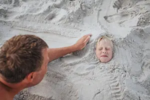 45 49 Years Prints: Boy buried in sand