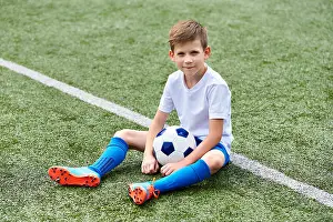 Sock Prints: Boy football soccer with ball sitting on a green grass