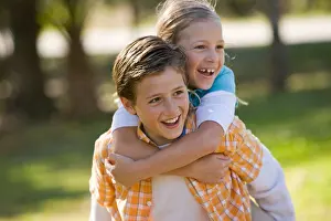 Siblings Prints: Boy giving piggyback ride to girl in park