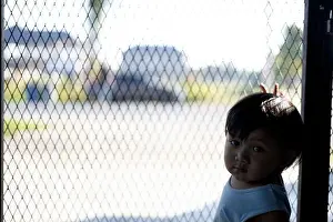 Hopelessness Prints: The boy is holding his hands on the fence