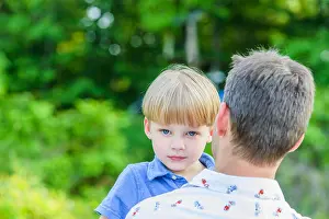 Nurturing Prints: Boy looking at camera over fathers shoulders