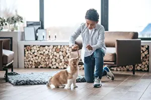 School Age Prints: A boy playing with a puppy and looking involved