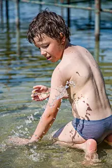 Boy playing with water and dirt in a polish lake