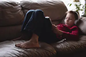 Homey Prints: Boy using digital tablet with headphones in living room