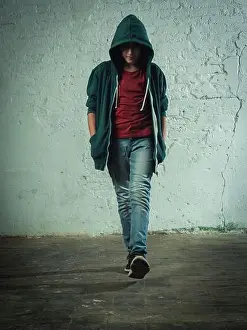 Hide Prints: Boy walking straight towards the camera with hoodie untied and hood up