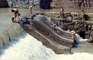 Boys and teenagers having fun in a river in the ancient town Feng Huang in Hunan Province of China