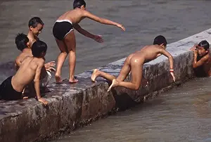 Boys and teenagers having fun in a river in the ancient town Feng Huang in Hunan Province of China