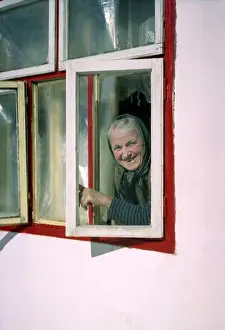 Lean Prints: Brasov County, Romania, approx. 2000. Local woman opening the windows of her house