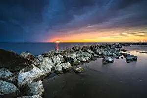 Daybreak Prints: Breakwater of large rocks in the Ijsselmeer near the town of Urk in the province of Flevoland during a dramatic sunset
