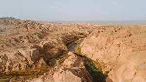 Uneven Prints: Breathtaking drone view of rough crack in dry soil of desert on sunny day in Iran