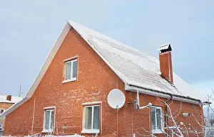 Roofing Prints: Brick house with a steep roof covered with snow