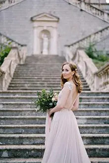 Railings Prints: Bride stands half-turned on the stone steps near the old building